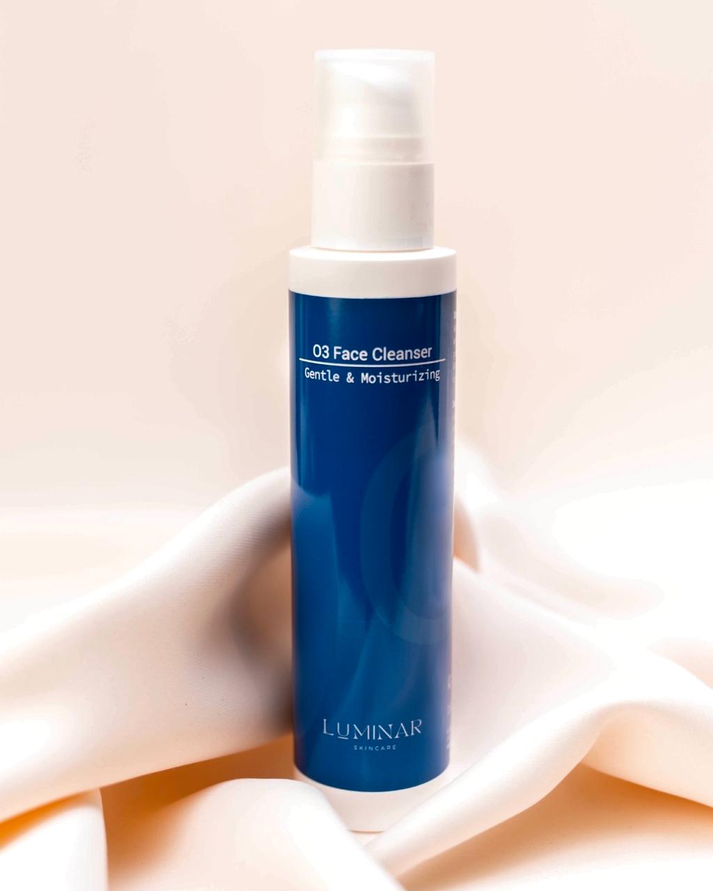 Luminar O3 Face Cleanser bottle resting on smooth, flowing peach fabric, reflecting purity and freshness.