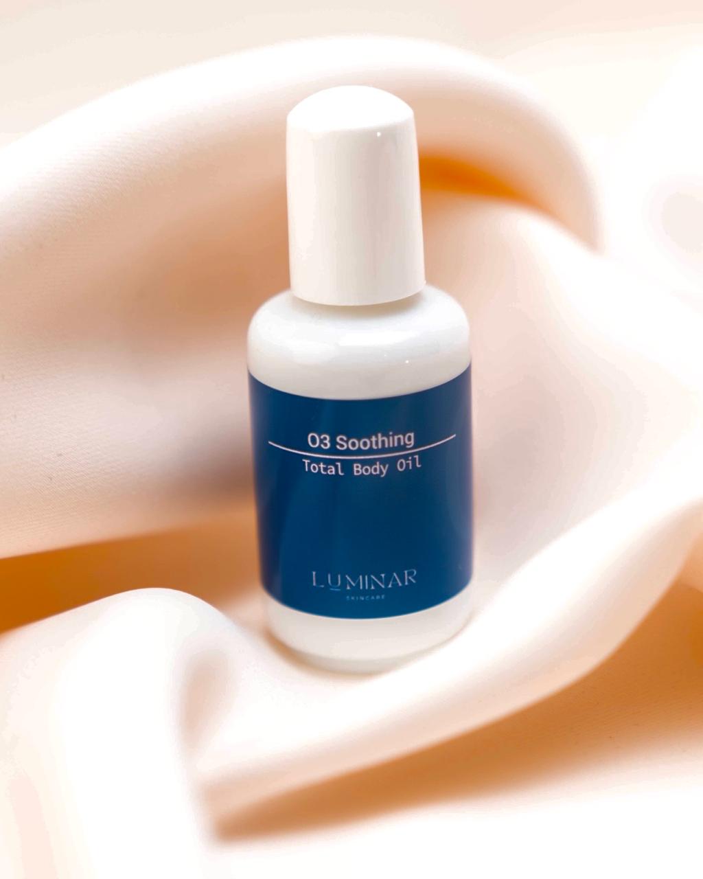 Luminar O3 Soothing oil bottle placed on soft peach fabric, creating a luxurious and calming aesthetic.