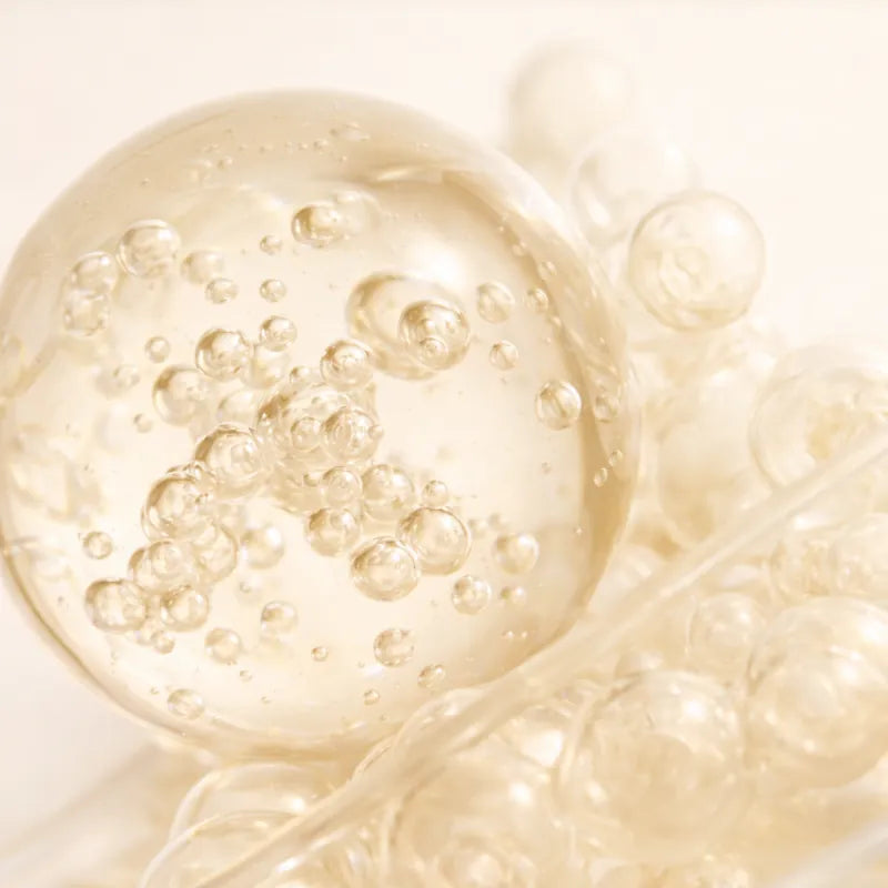 Macro image of translucent microbubbles suspended in a creamy liquid, representing oxygenation and hand skin renewal.
