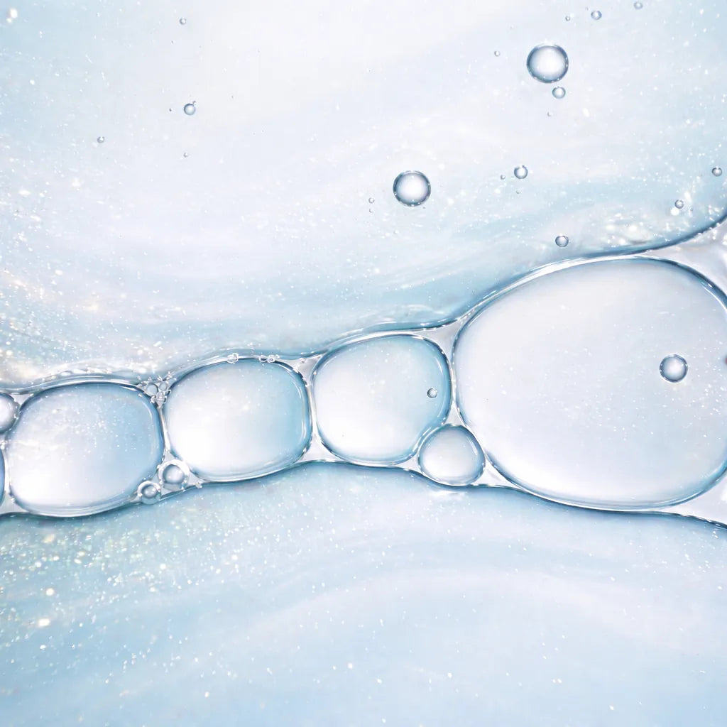 Abstract macro image of translucent bubbles in a soft blue liquid, representing targeted relief and skin repair.