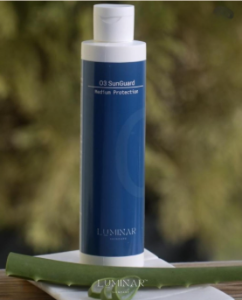 Blue bottle labeled '03 SunGuard' on a white surface with a blurred green background