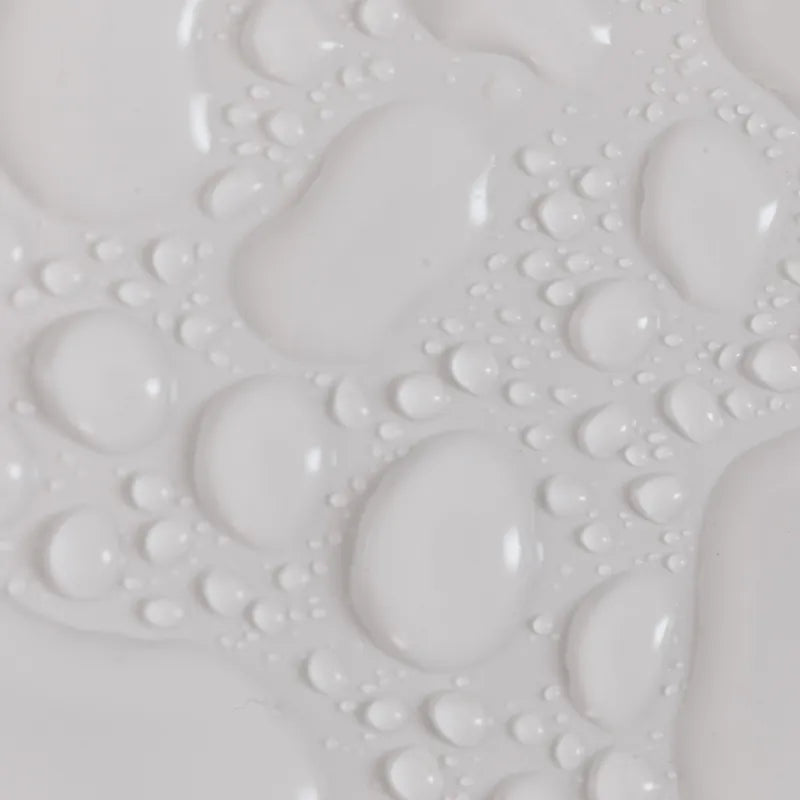 Close-up abstract texture of clear liquid droplets on a white surface, representing hydrating skincare serum or moisturizer.